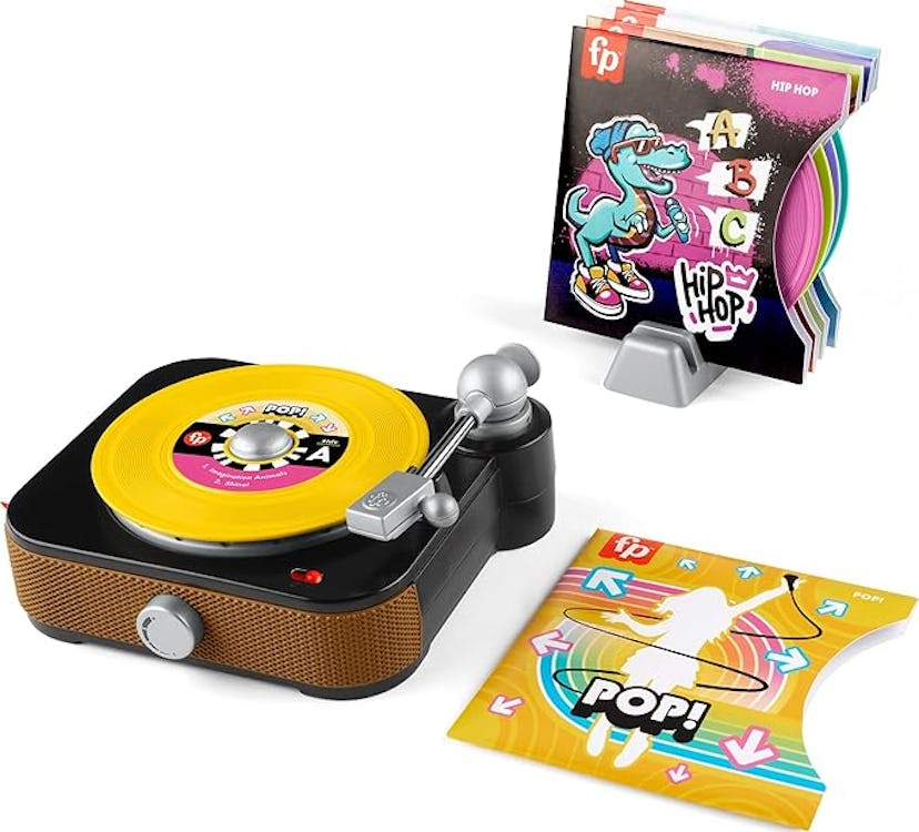 A toy turntable with a yellow record, colorful music cards, and a cheerful cartoon dinosaur characte...