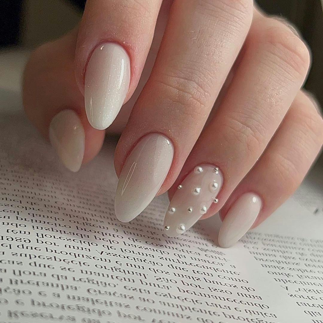 Neutral nails with pearls match the preppy aesthetic.