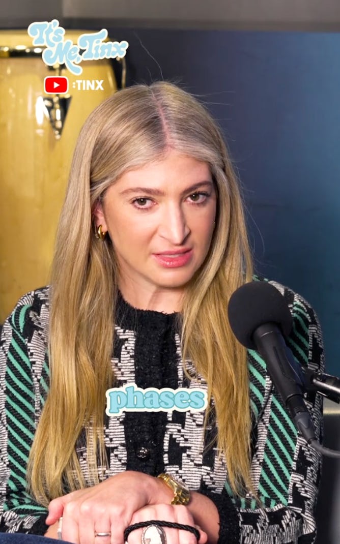 A woman with long blonde hair sits at a microphone, expressing a thoughtful demeanor. The backdrop includes musical instruments and the text 