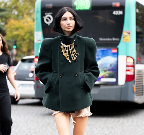 A guest wears pink shorts, beige long sock, black leather military boots, a gold pendant necklace an...
