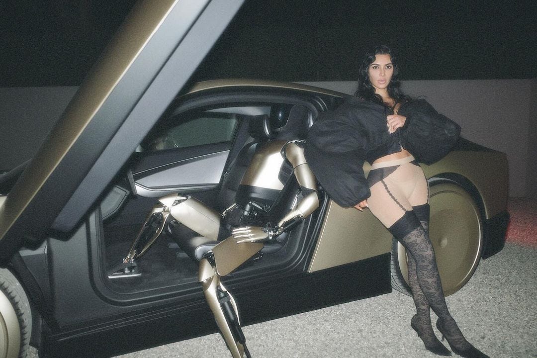 Kim Kardashian wears a puffy bomber and sheer tights.