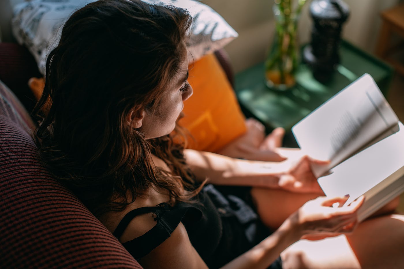 A woman reads a sexy book in her bedroom.