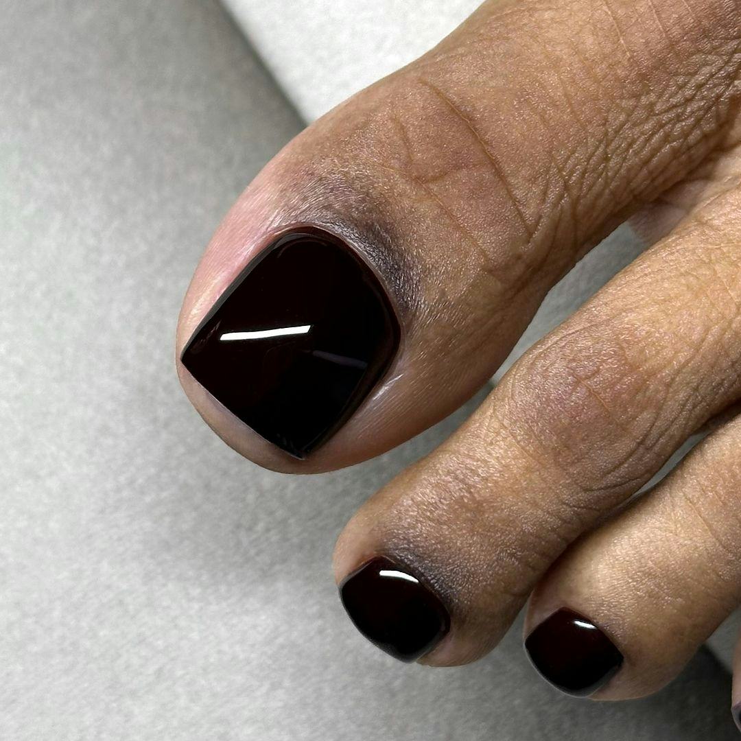Black pedicures are on-trend for winter 2025.