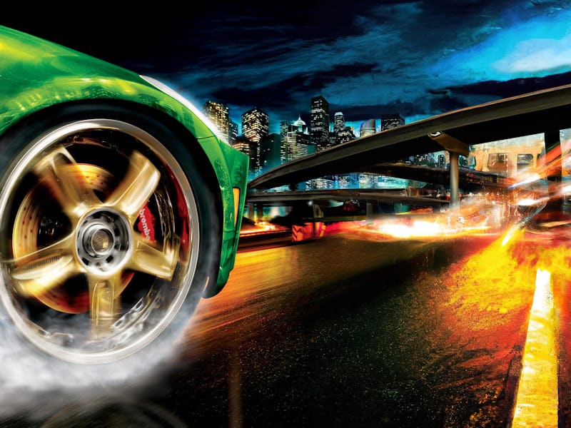 A green car pulls off with smoke coming off its tires