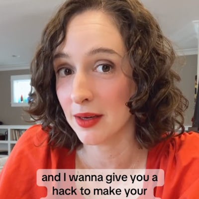A woman with curly hair and a red top speaks to the camera, sharing tips on making effective apologies. The background is a bright, cozy room.