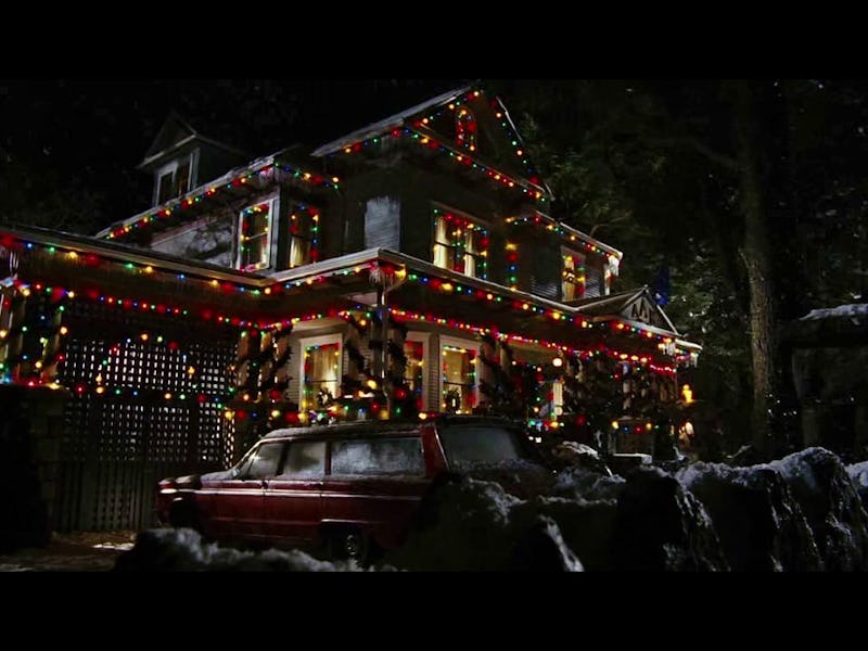 A snowy house adorned with colorful Christmas lights, featuring a festive atmosphere at night, with ...