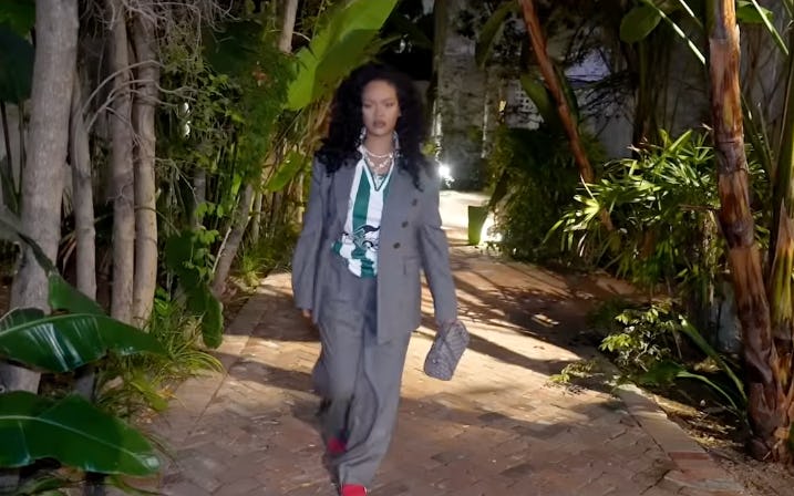 Rihanna wears a gray pantsuit, soccer shirt, and Fenty X Puma sneakers.
