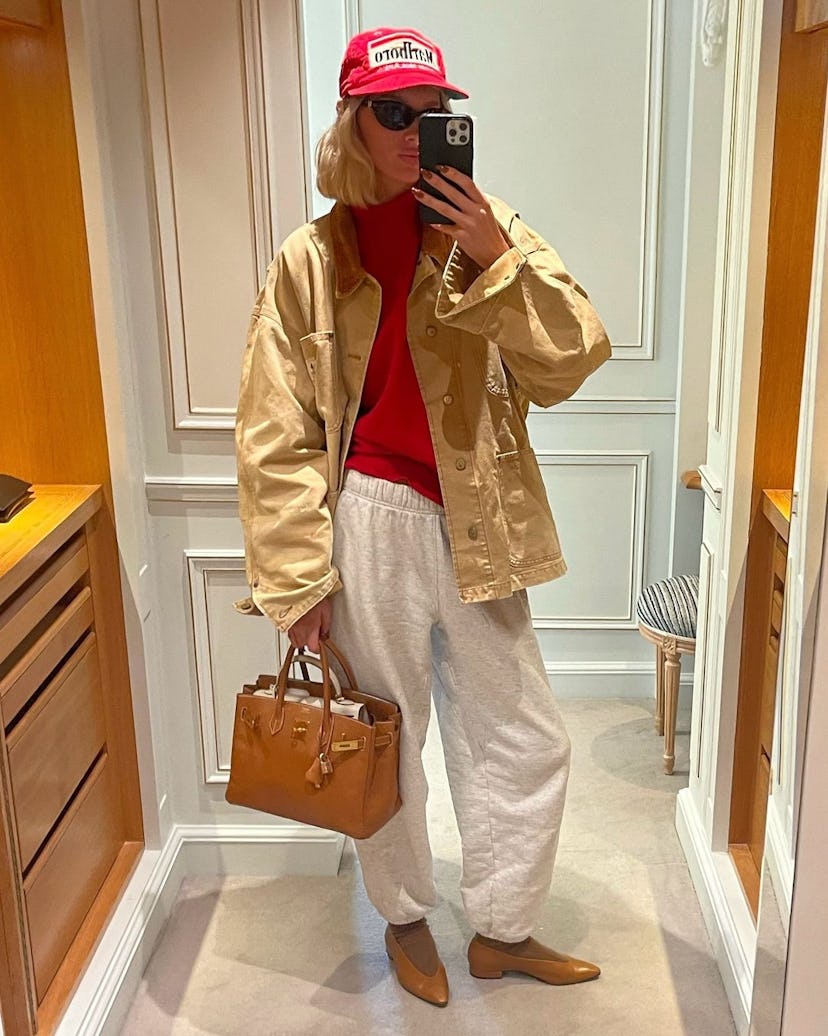 Elsa Hosk wears a red sweater, gray sweatpants, and a Birkin.