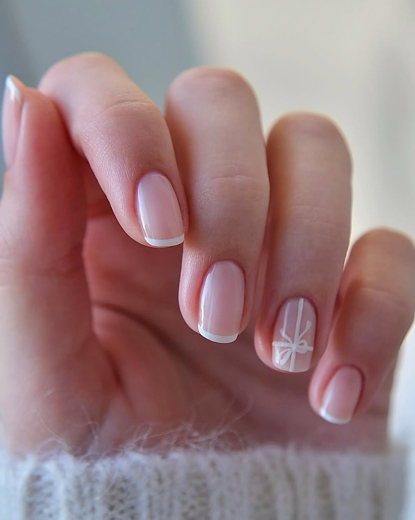 Try minimal French tip nails with a gift ribbon detail for Christmas 2024.