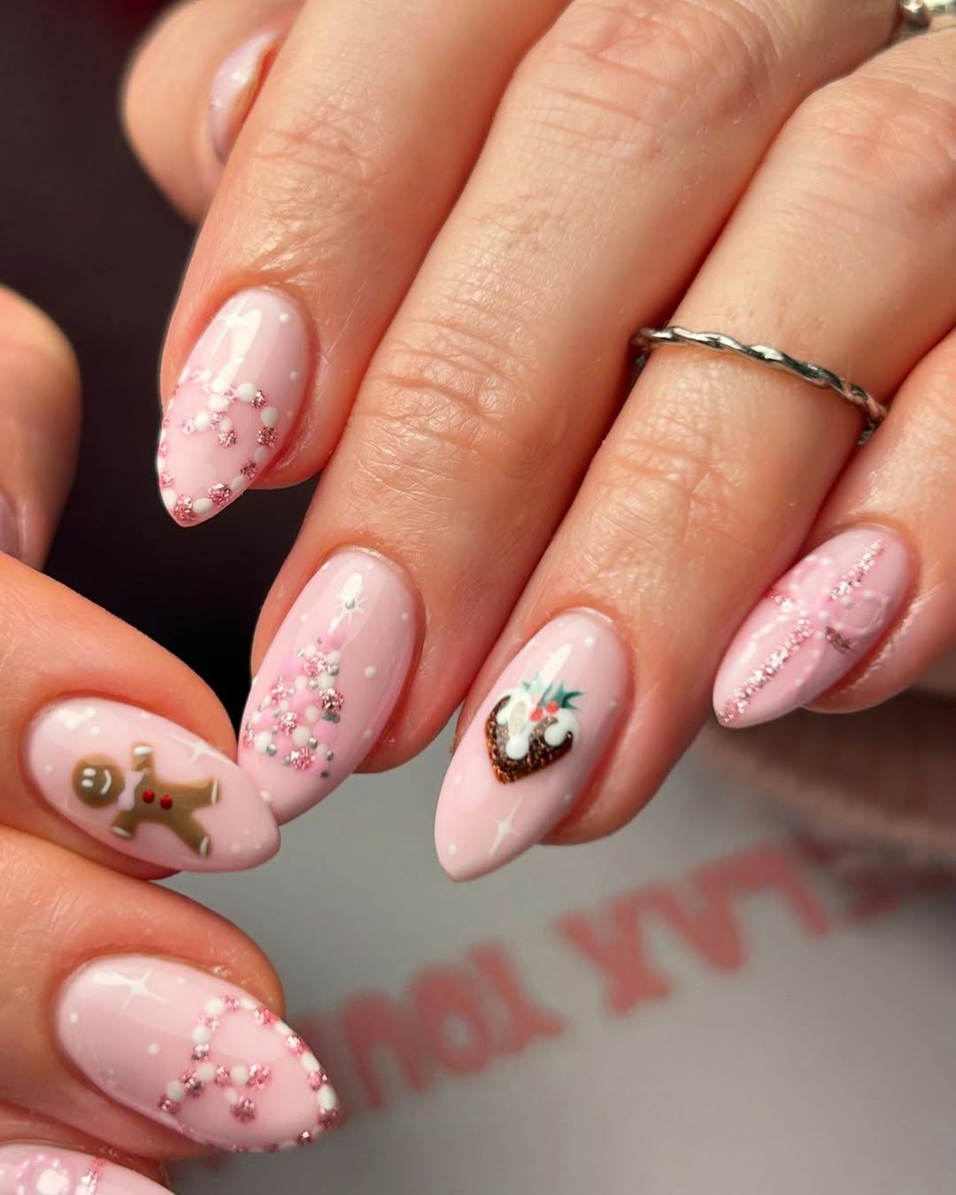 Try pink nails with coquette holiday art for Christmas 2024.