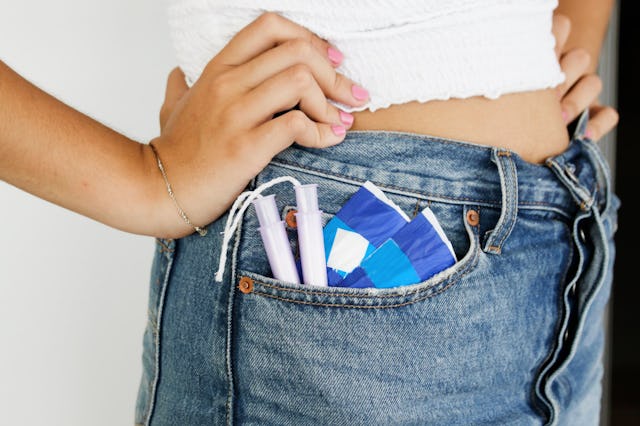 A young woman with sanitary pads and tampons in pocket
