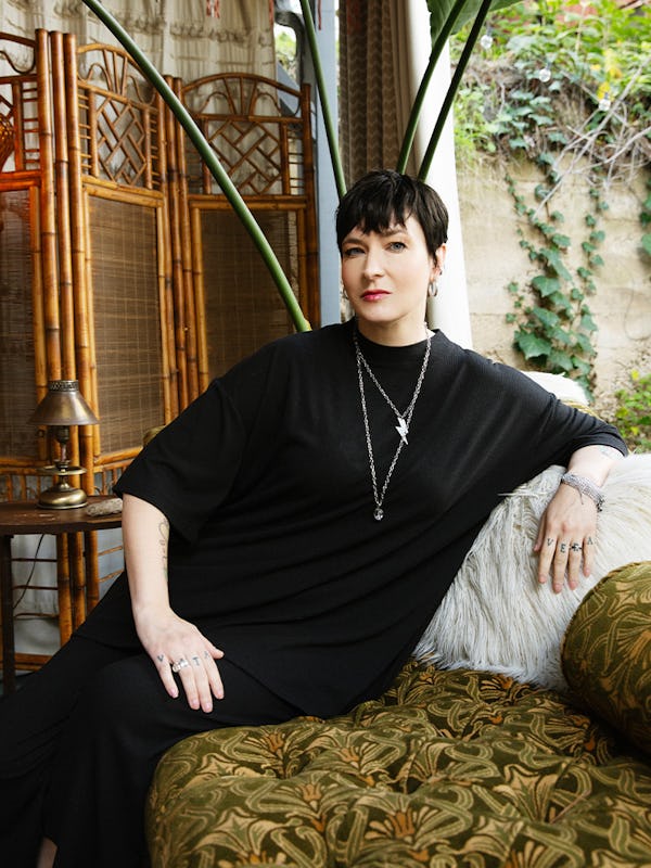 Diablo Cody, screenwriter of ‘Juno,’ sits on a printed couch, with a wooden screen behind her.