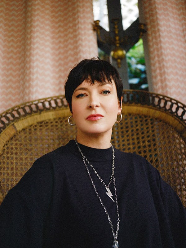 Diablo Cody sits in a wicker chair and looks at the camera.