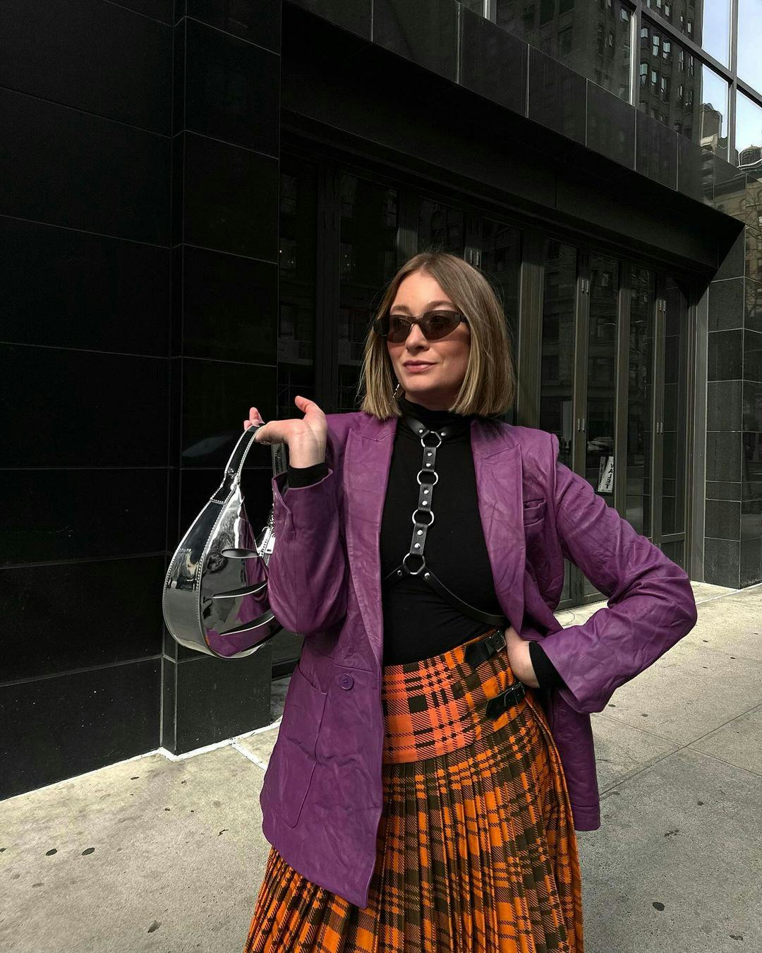 kelsey stiegman at new york fashion week in a plaid skirt and leather blazer