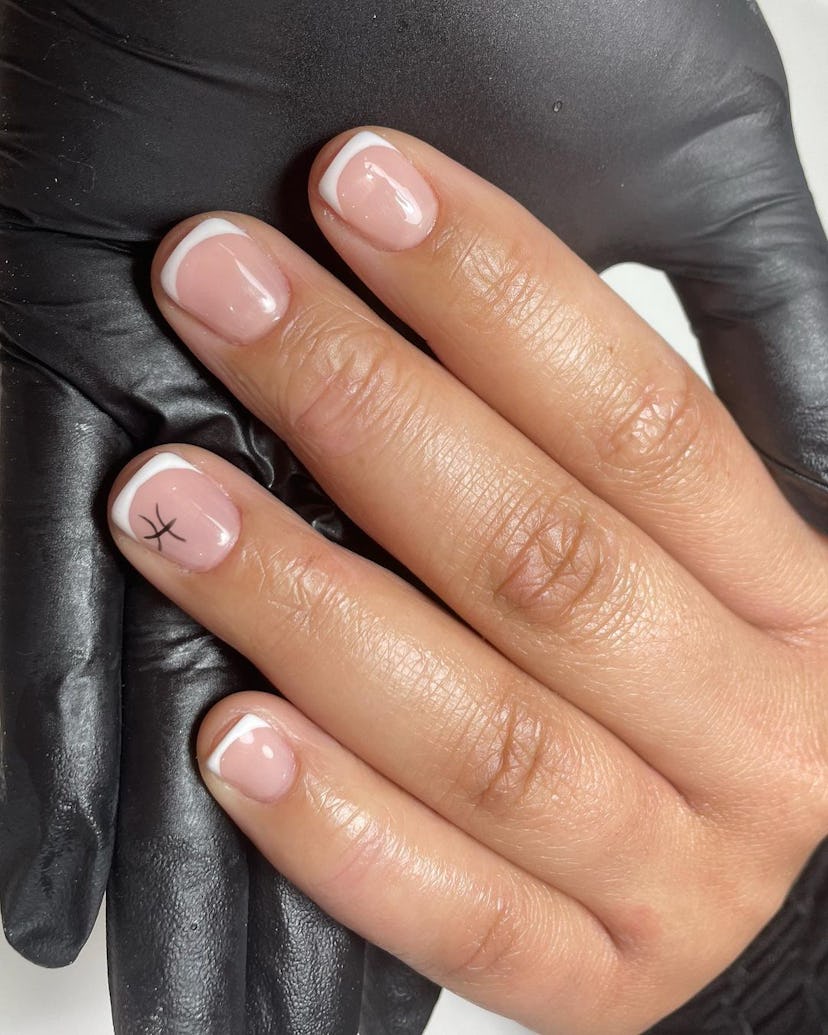 Micro French tip nails with a tiny Pisces symbol are on-trend for Pisces season 2024.