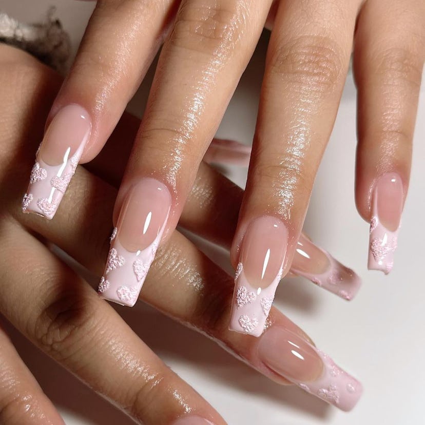 Pink French tip nails with textured heart designs are on-trend for Pisces season 2024.