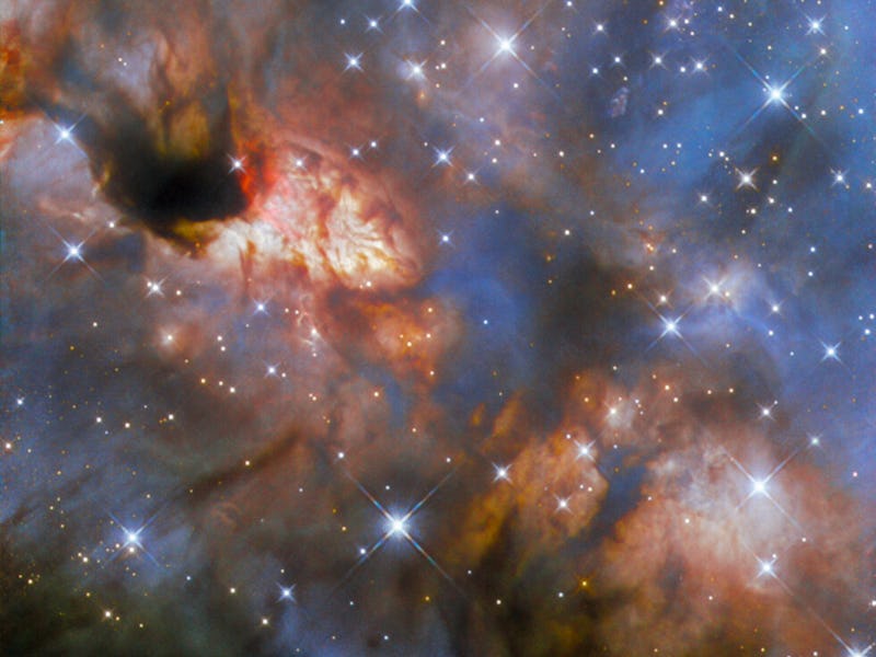 A nebula with stars. The centre of the image from top-left to bottom-right glows brightly with light...