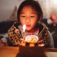 A child blows out the birthday candle on their cake.