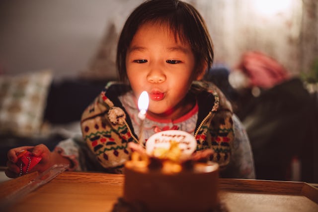 A child blows out the birthday candle on their cake.