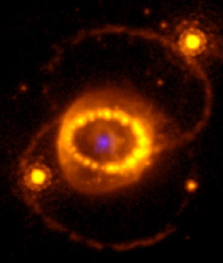 image of an orange circle of supernova debris with a blue spot at the center
