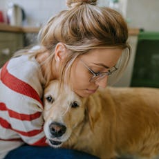 A woman hugs her dog.