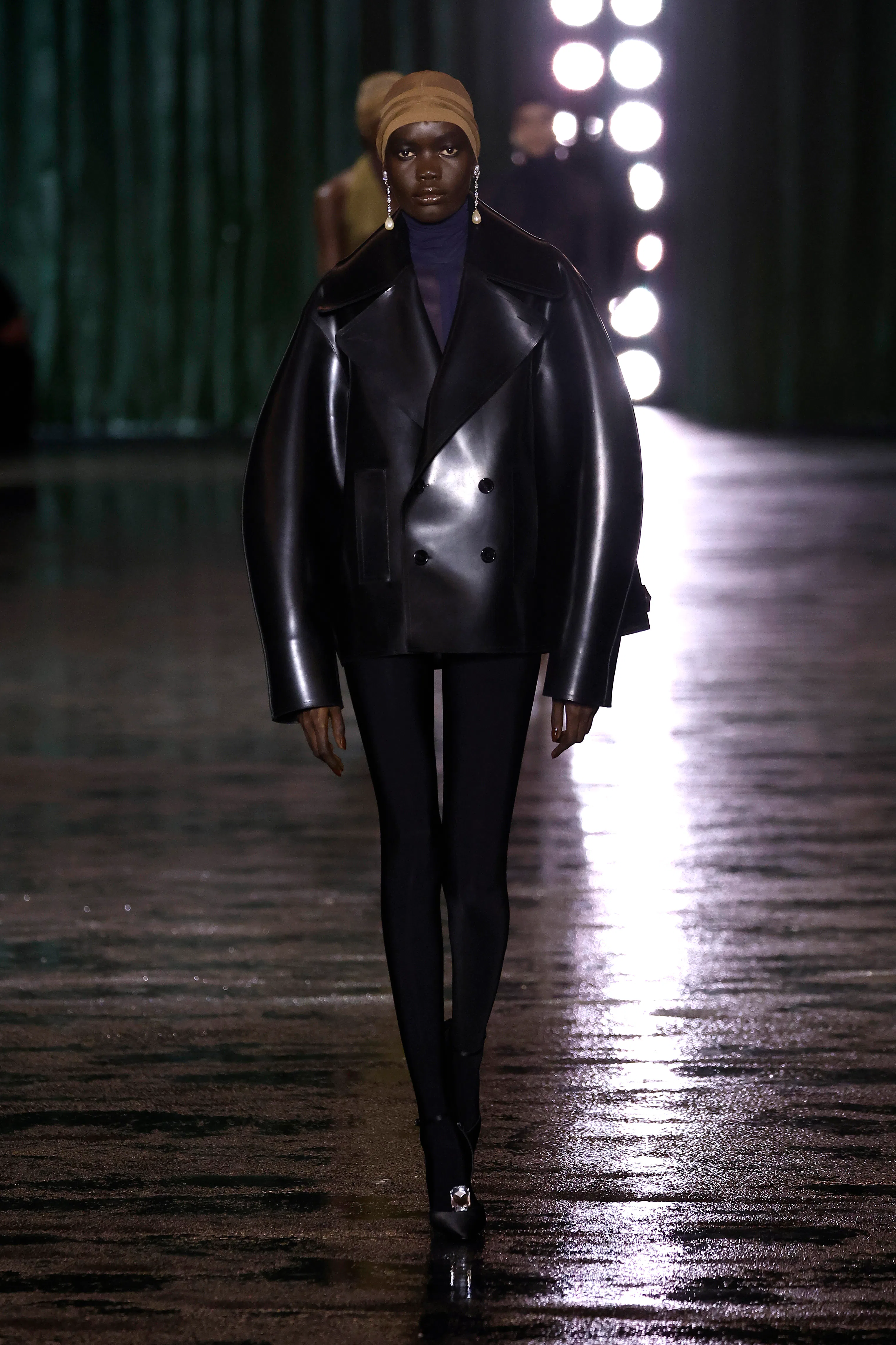 Bir model, Saint Laurent Kadın Giyim Sonbahar/Kış 2024-2025 defilesi sırasında podyumda yürüyor.