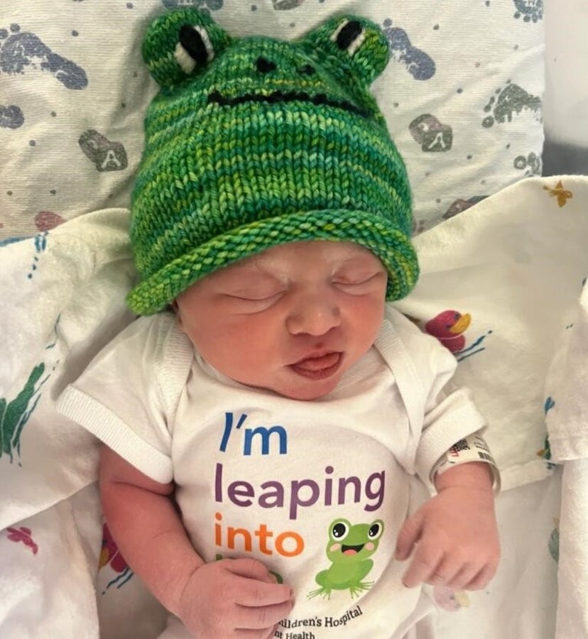 A baby girl born on Leap Day in a little frog hat.