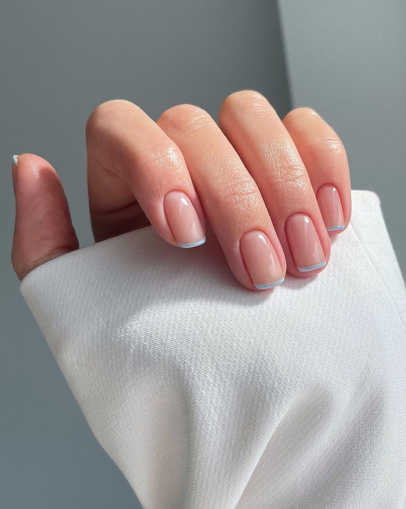 Baby blue micro French tip nails are on-trend.