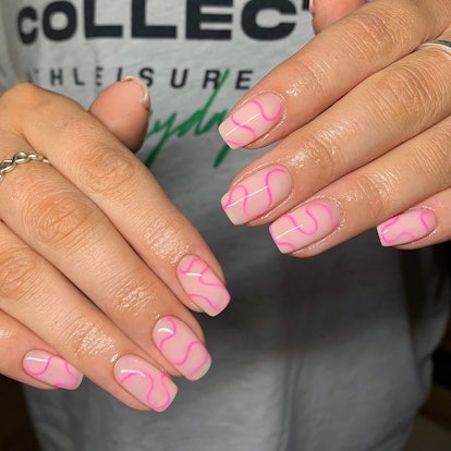 Neutral nails with pink swirl designs are on-trend for 2024.
