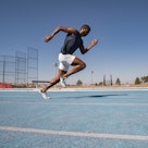 A man running on a track, doing the Beep Test.