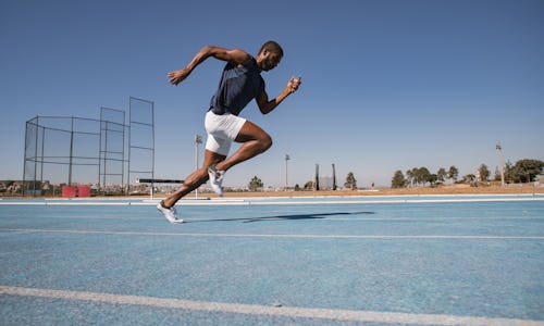 A man running on a track, doing the Beep Test.