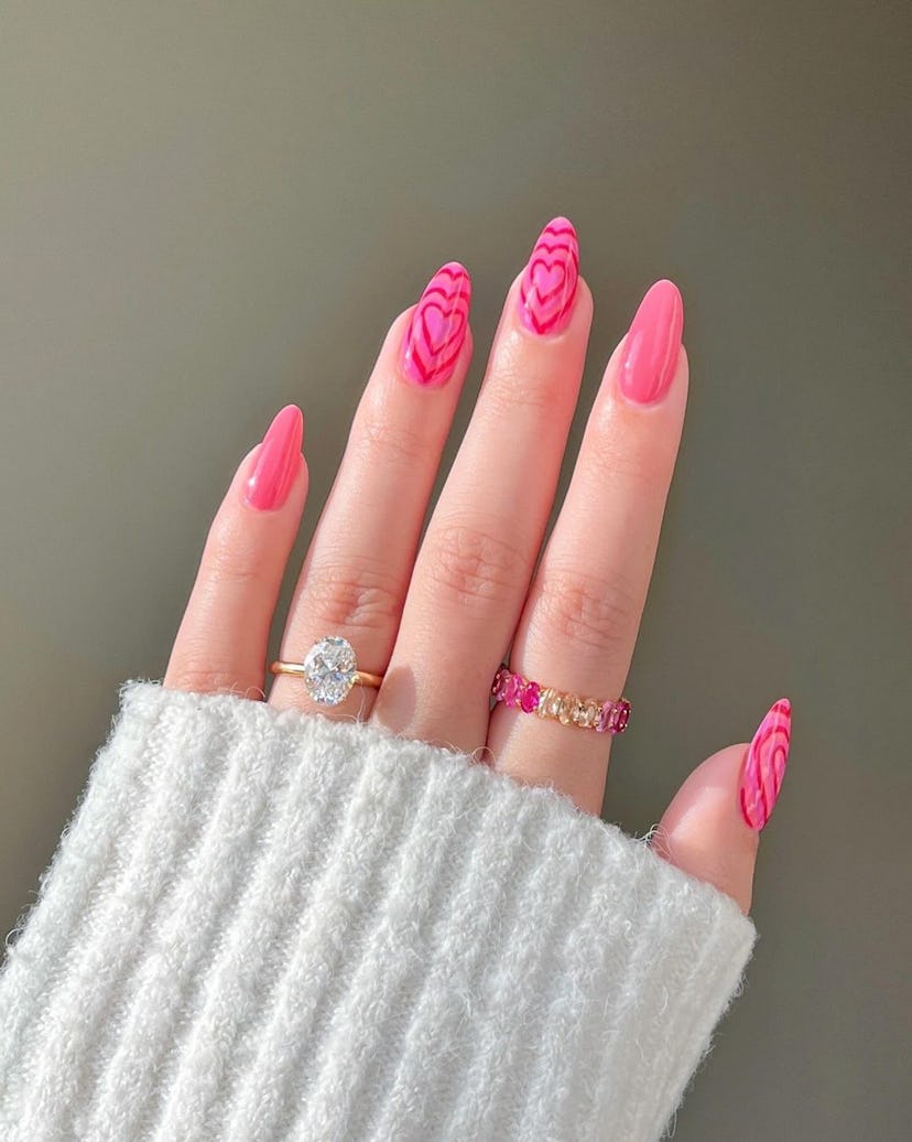 Layered love heart designs on statement nails are on-trend for 2024.