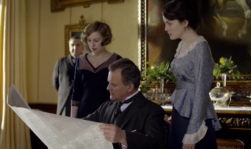 Lady Edith and Lady Mary flank Lord Grantham as he reads the paper in 'Downton Abbey.'