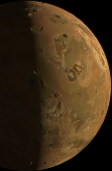 A detailed image of the planet Mars, showing its reddish surface and dark markings against the black...