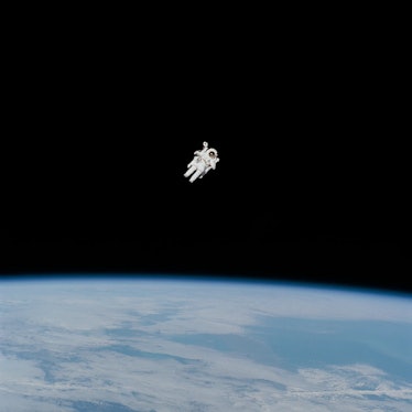 An astronaut flies above the Earth. The astronaut is at a great distance from the viewer, and no cab...