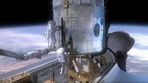 Two American astronauts work on a capsule orbiting earth.