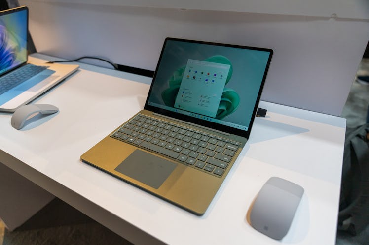 The Surface Laptop Go 3 on a white counter with a computer mouse on the right side.