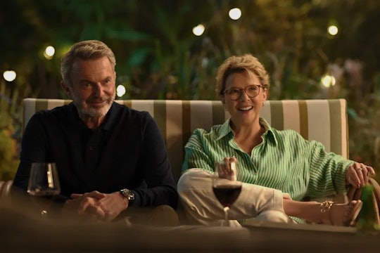 Sam Neill and Annette Bening as Stan and Joy Delaney, sitting on a couch with red wine in ‘Apples Ne...