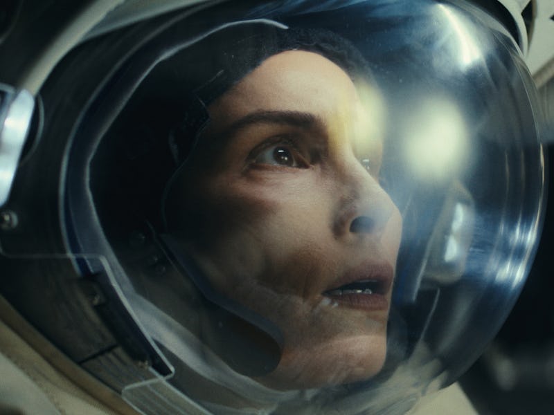 Close-up of a focused astronaut wearing a helmet, with reflections visible on the visor.