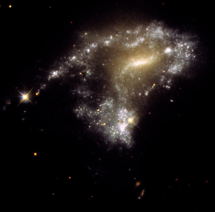 A Hubble Space Telescope image of galaxy AM 1054-325. It has been distorted into an S-shape from a n...