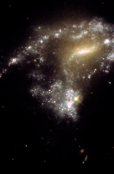 A Hubble Space Telescope image of galaxy AM 1054-325. It has been distorted into an S-shape from a n...