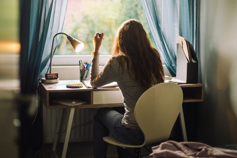 A teen girl sits at her desk studying.