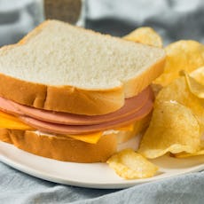 A bologna sandwich with chips.