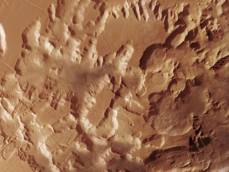 Aerial view of a rugged, textured Martian landscape with undulating terrain and crater impacts.