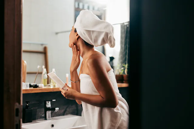 A woman applies self-tanner.
