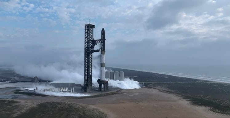 photo of a rocket on a launch pad with the ocean in the background.