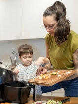 A woman and her son make dinner in the air fryer.