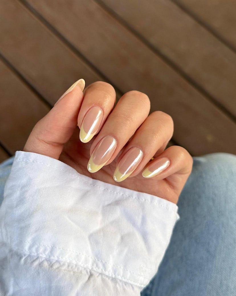 Pastel yellow chrome French tip nails are on-trend for spring 2024.