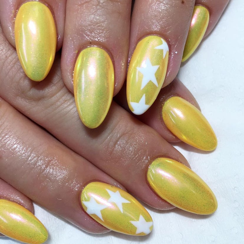 Yellow chrome nails with star details are on-trend for spring 2024.