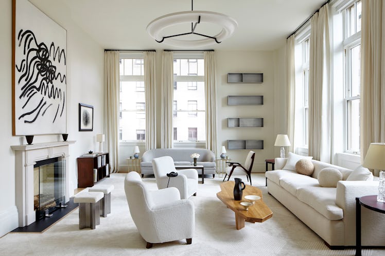 An elegant living room decorated in shades of white with contemporary art on display